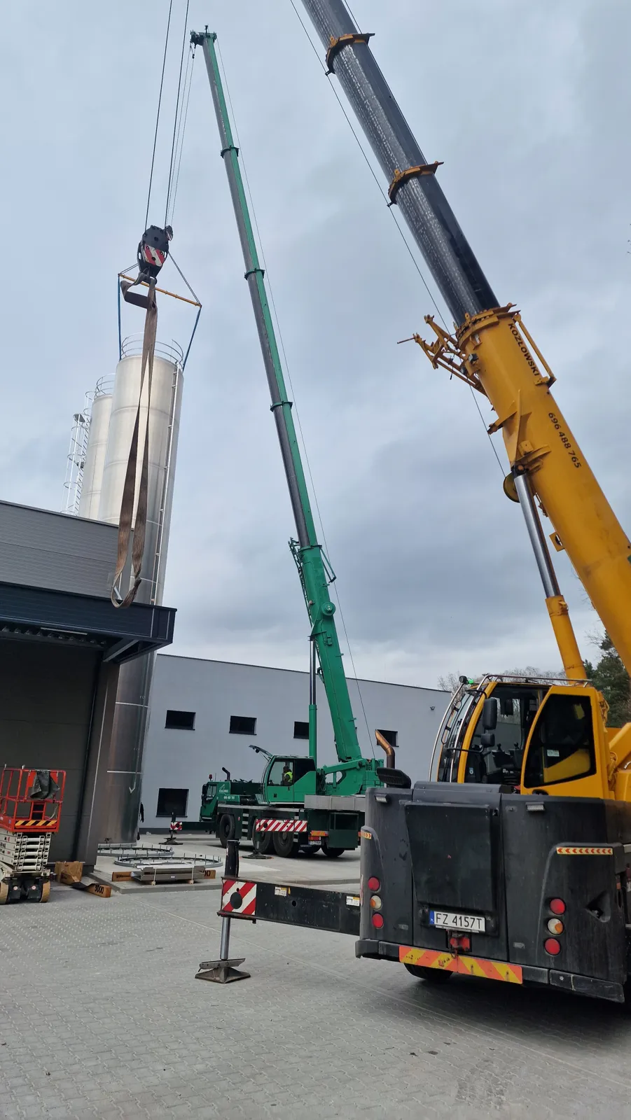 Dwa dźwigi Liebherr stawiają silos w tandemie