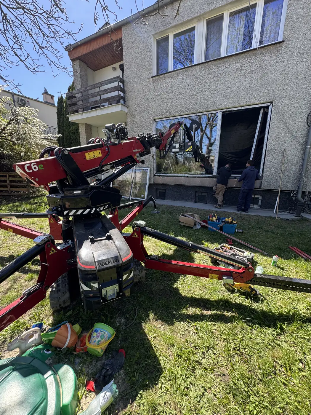 Szyba 400 kg niesiona przez ogród do salonu